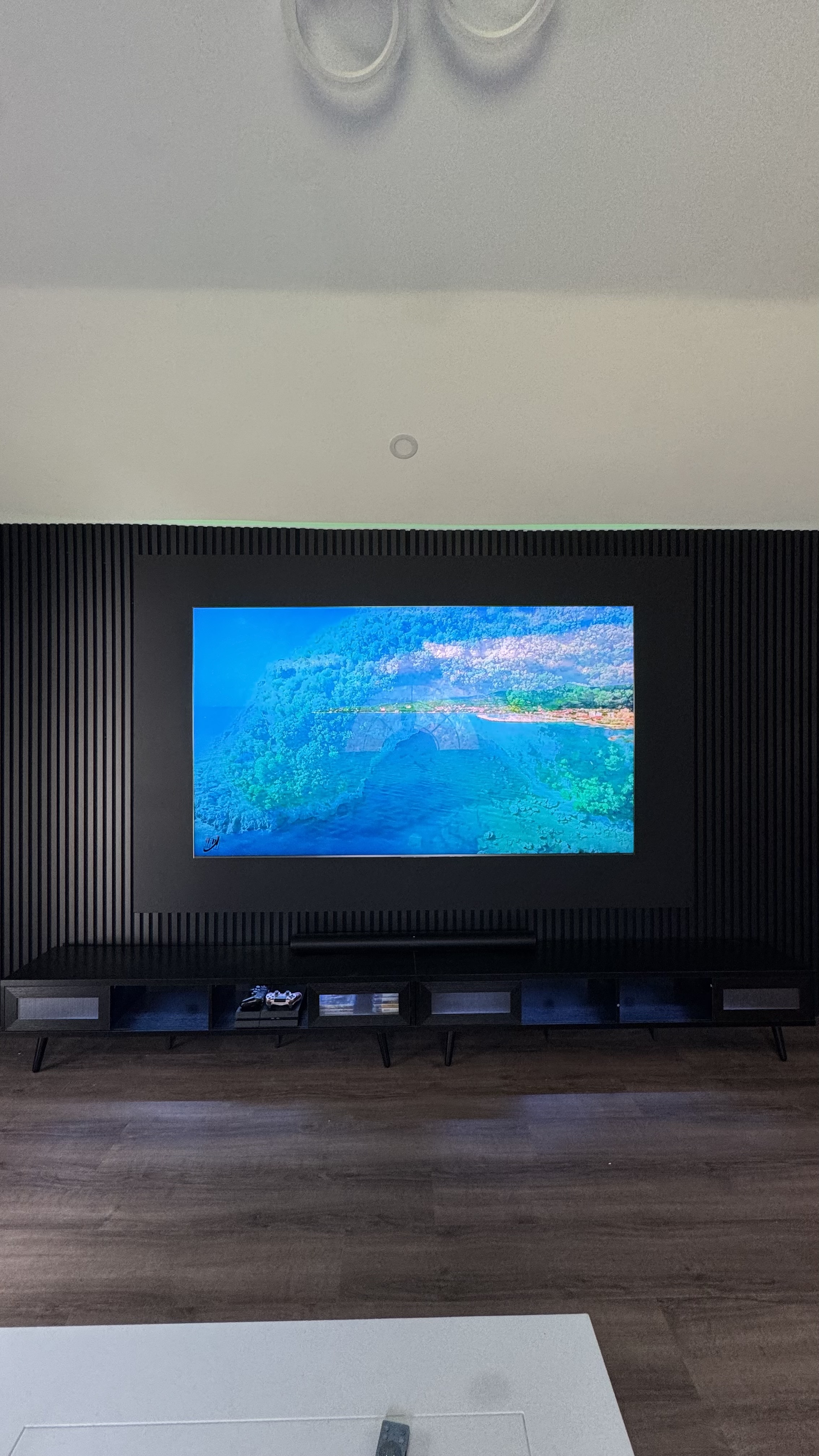 The Eclipse, a custom media wall built by SEIN ME in New Jersey. Full slat wall with a backdrop panel behind the TV, a low floating console and glow lighting.
