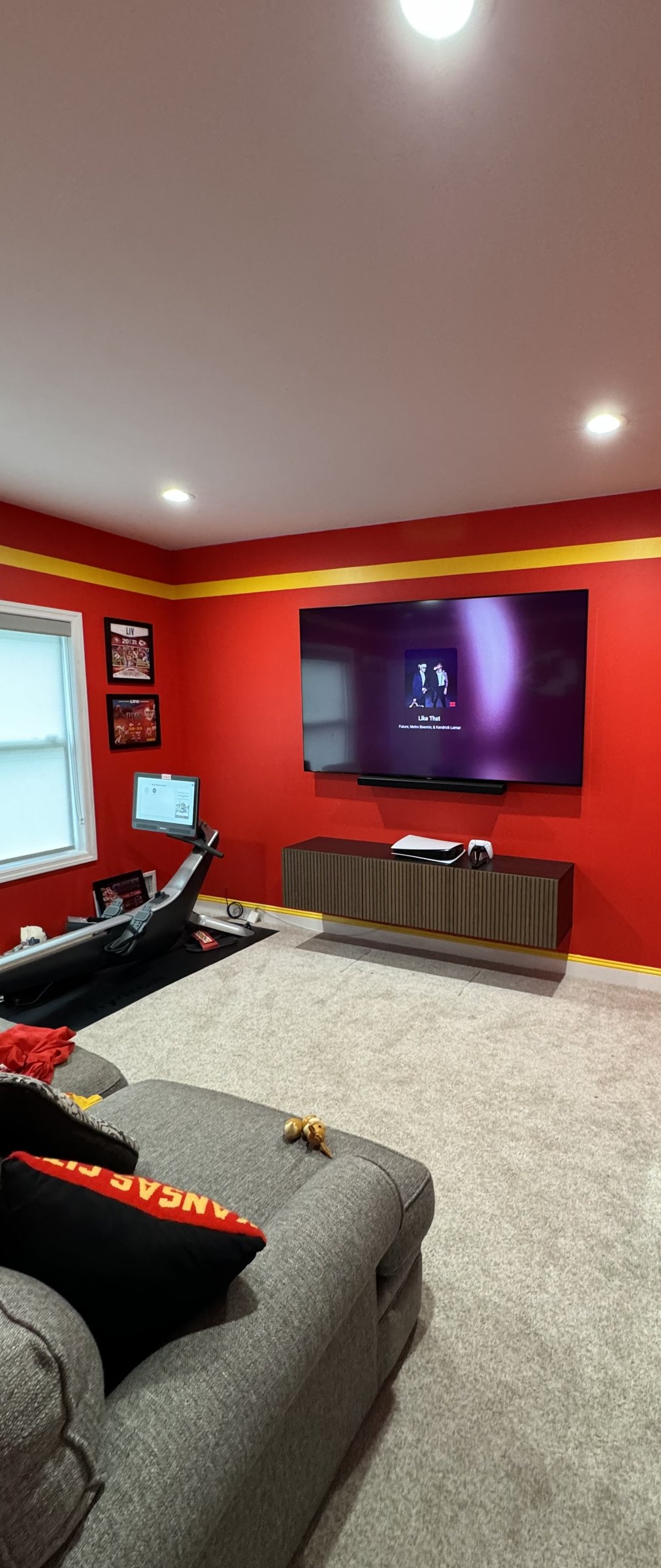 The Old Bridge fan cave room with the TV wall, red walls and gold stripe, by SEIN ME