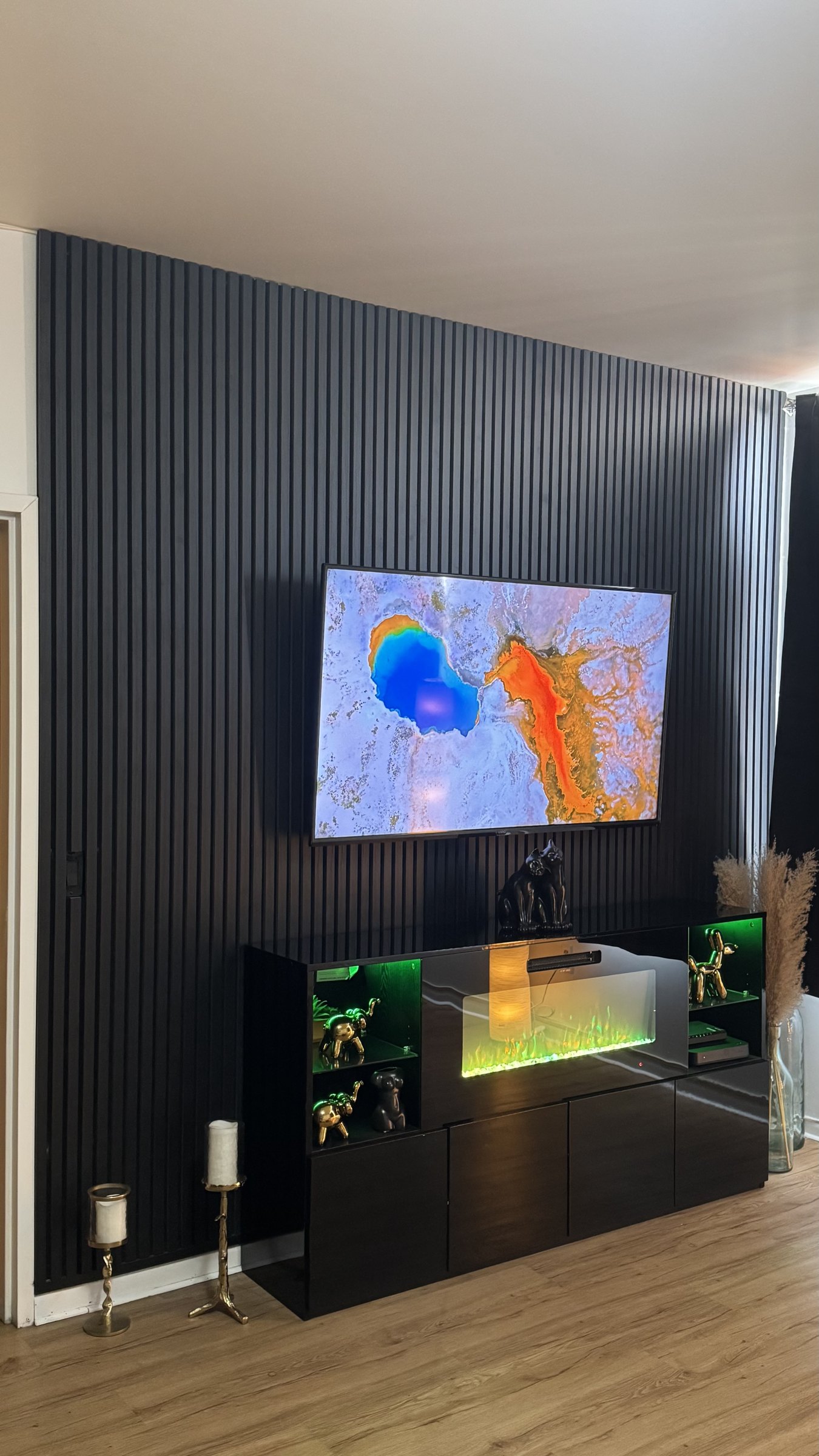 Angled view of the black slat wall with fireplace insert glowing in the display console by SEIN ME in Plainfield, New Jersey