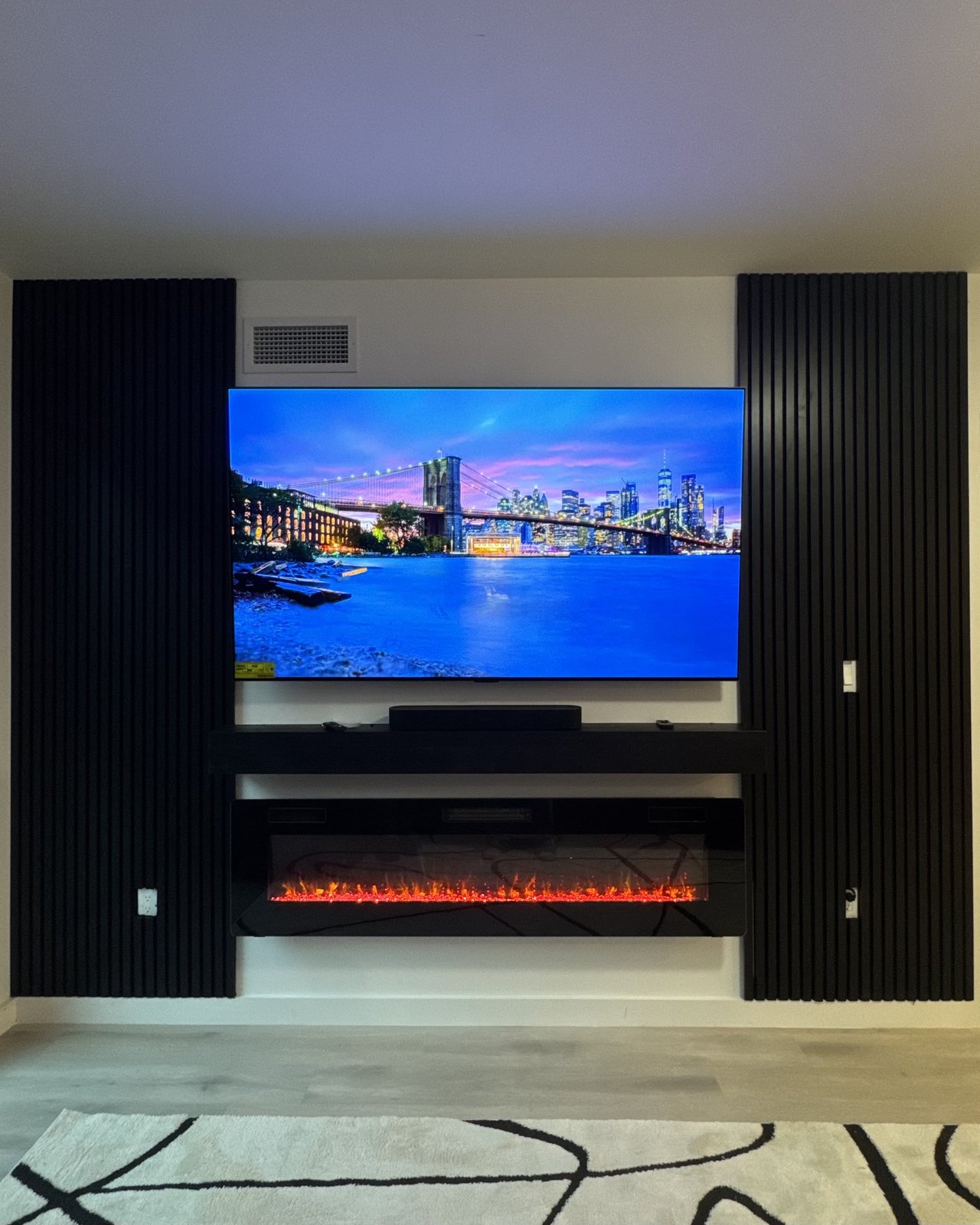 Framed Center Wall: Black slats flanking a white center with floating soundbar shelf, by SEIN ME