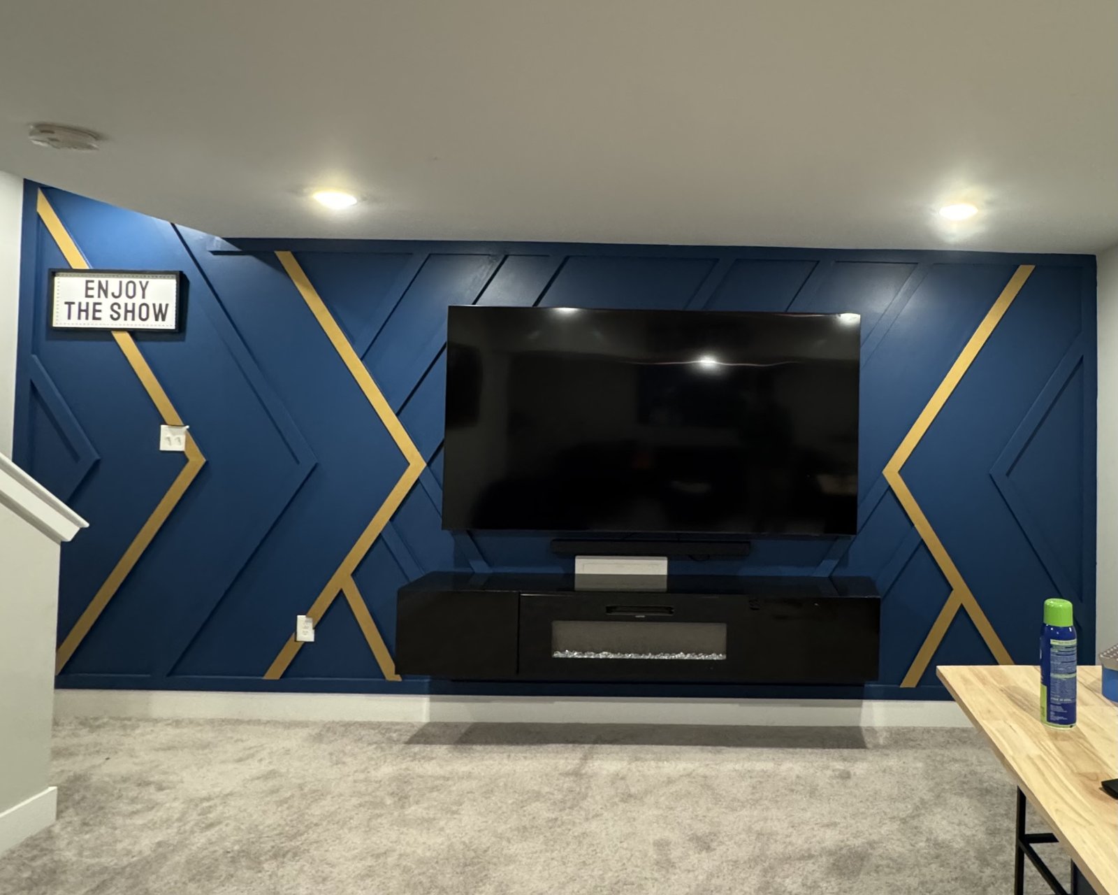 Navy board-and-batten accent wall with gold X inlays and fire console by SEIN ME in Blackwood, New Jersey