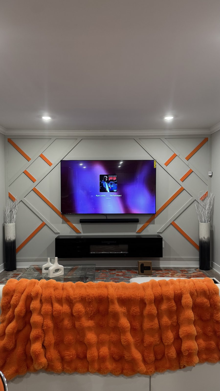 Light gray board-and-batten accent wall with orange inlays and black console by SEIN ME in Blackwood, New Jersey
