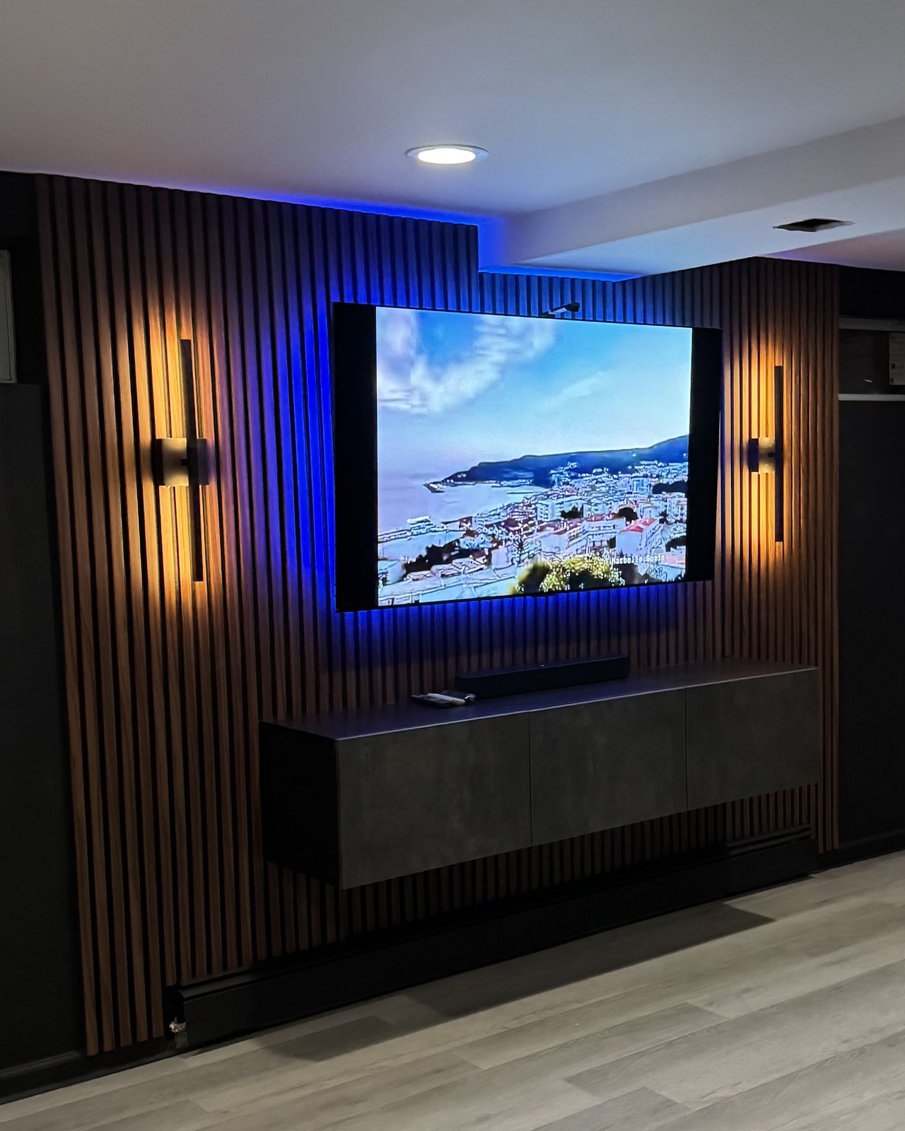 Walnut Slat Wall: blue LED behind the TV with warm sconces, by SEIN ME in Piscataway, New Jersey