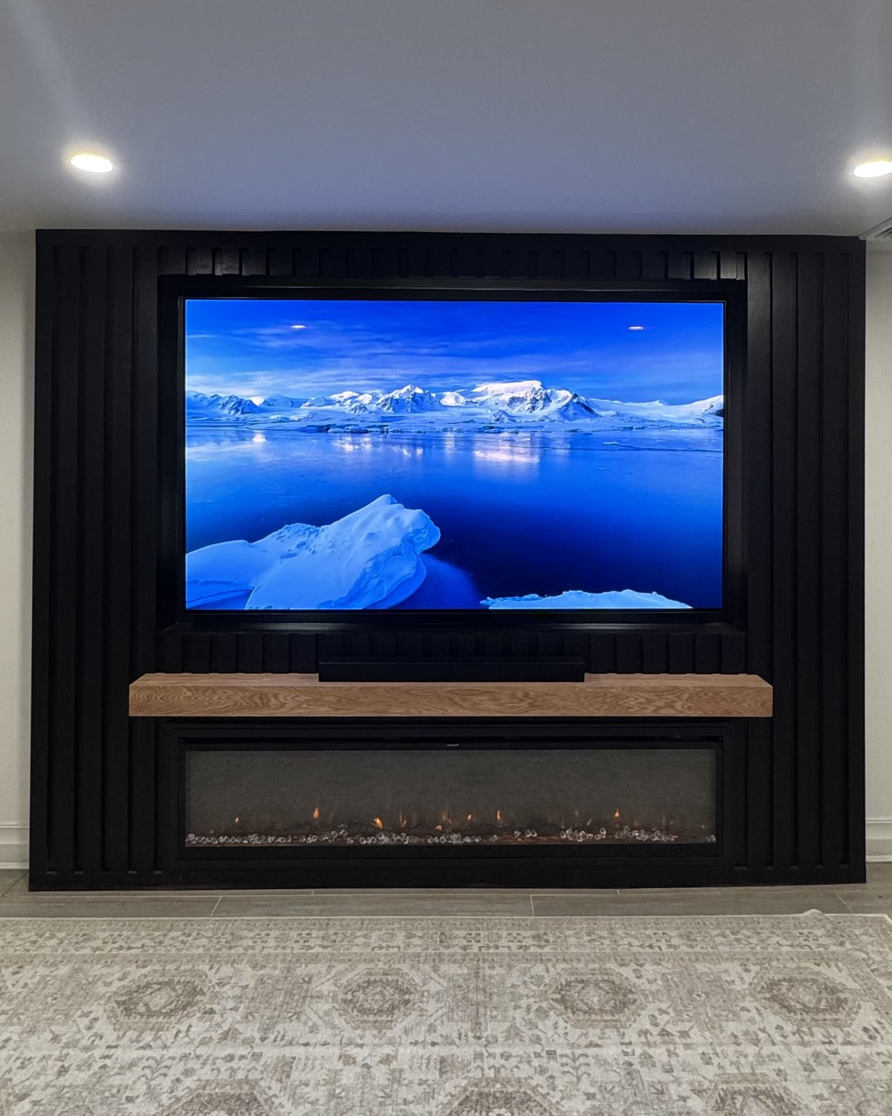 8 foot black slat media wall with fireplace and oak mantel by SEIN ME in Short Hills, New Jersey