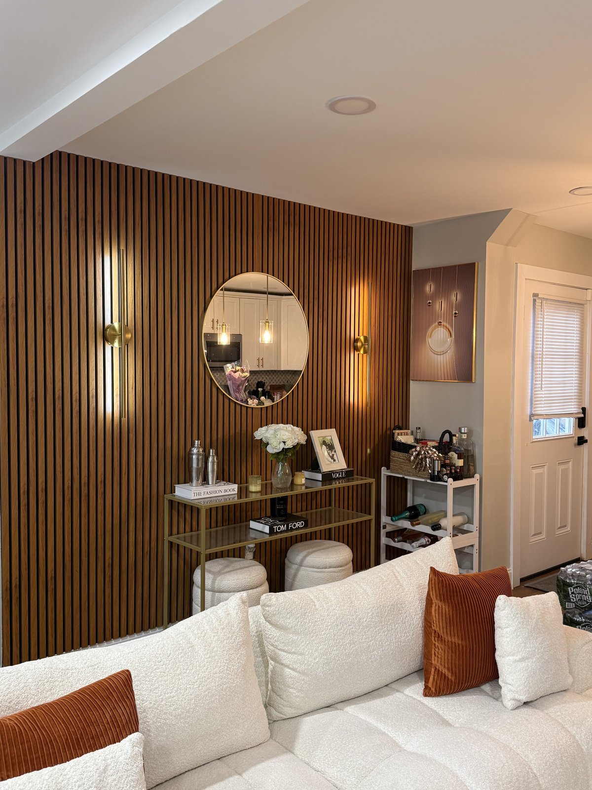 The Supper Club, a renter friendly accent wall built by SEIN ME in New Jersey. Wood slat dining wall with a round mirror, a mounted picture and battery sconces. No TV, no wiring.