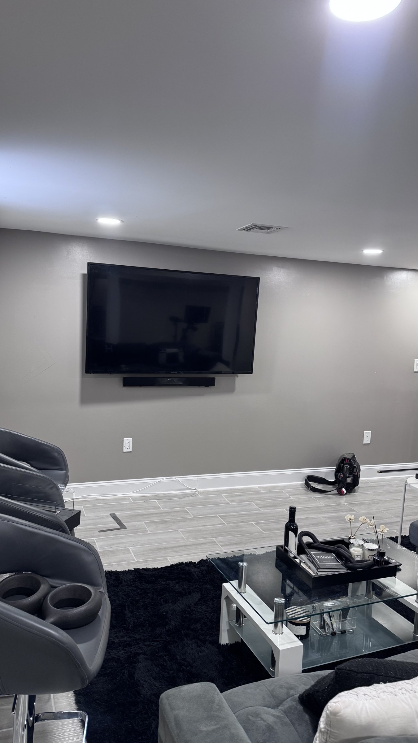 The Union basement before the build, a bare gray wall with a TV and soundbar, by SEIN ME