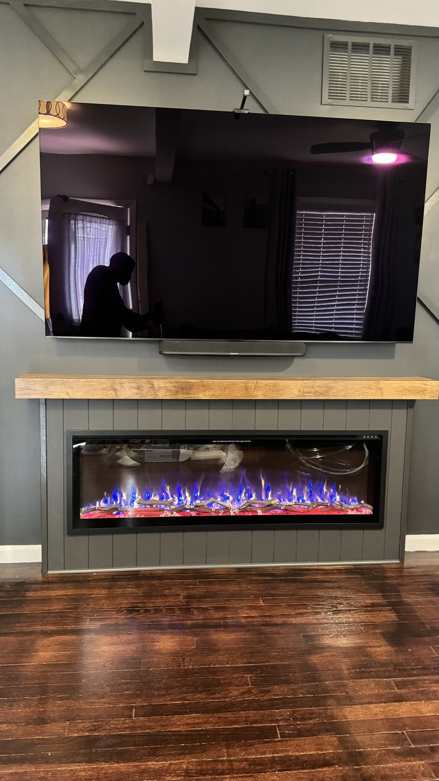 Charcoal fireplace media wall built and lit, straight-on view, by SEIN ME in Plainfield, New Jersey
