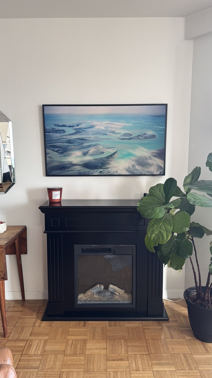 Freestanding Mantel & Frame TV: Coastal art above a black freestanding electric mantel, by SEIN ME