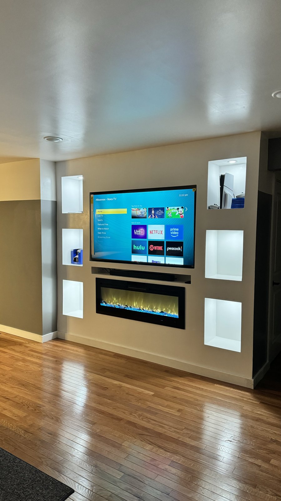 Angled view of the six-niche display wall with fireplace lit by SEIN ME in Metuchen, New Jersey