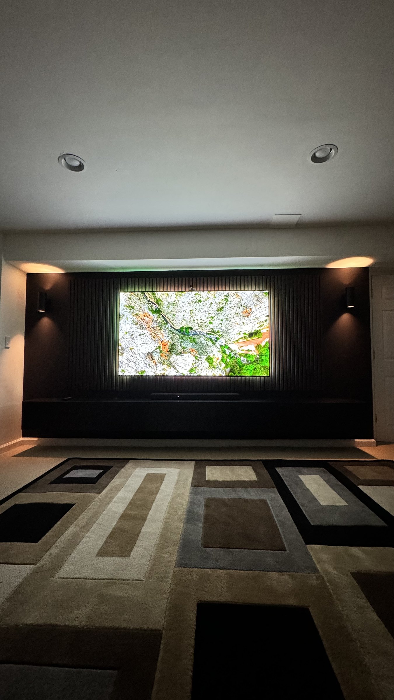 The finished South River media wall at night with warm sconces and halo backlight, by SEIN ME