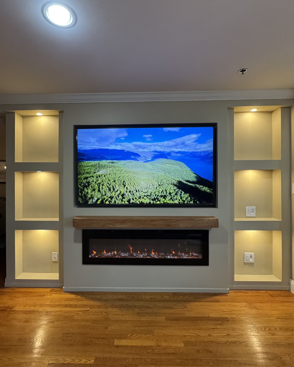 Full custom media wall in New Jersey with lit display wings, oak mantel and linear fireplace